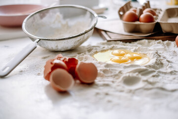 Chicken eggs in flour on the kitchen table, ingredients. Preparation for baking, culinary recipes.