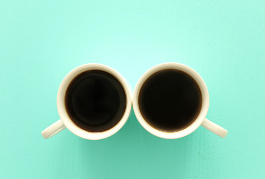 Top view image of two coffe cups on mint pastel background. Flat lay. Copy space