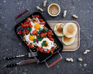 Fried eggs with tomatoes and pancakes with peanut paste