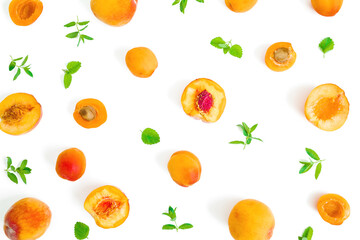 Fruit pattern of ripe apricot and peaches with leaves on white background. Flat lay