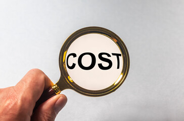 Hand Showing Cost Word Through Magnifying Glass