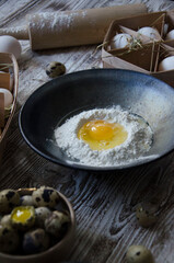 Ingredients for baking: egg poured into bowl with flour