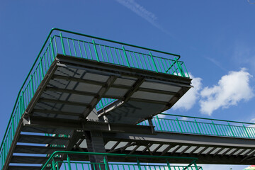 fragment of metal green multi-level staircase, transition on the street to the bridge or across the road