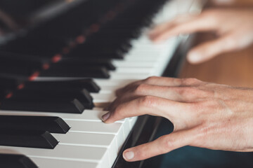 Fototapeta premium Playing piano at home, high angle view, blurry background.
