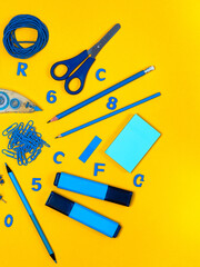 Blue school stationery on yellow background Office tools Abstract background