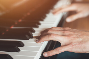 Playing piano at home, high angle view, blurry background.