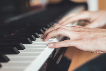 Obraz premium Playing piano at home, high angle view, blurry background.