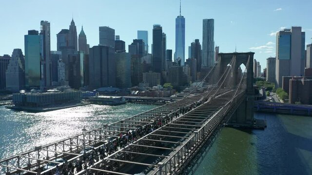 alt flying backward view of BLM marchers streaming across Brooklyn Bridge towards NYC