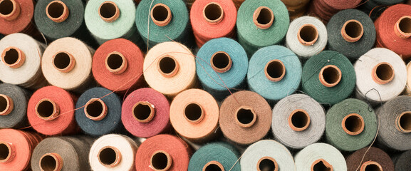 Threads in a tailor textile fabric: colorful cotton threads, birds eye perspective - obrazy, fototapety, plakaty