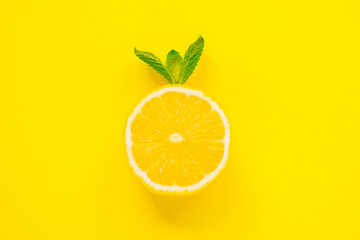 Summer concept. Sliced fresh lemon and mint on yellow background. Creative minimalizm. Top view and flat lay.
