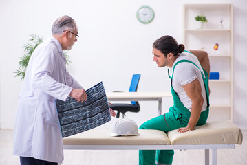 Obraz premium Young male contractor visiting old doctor