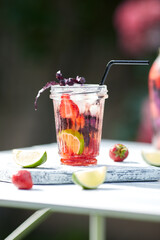 Delicious refreshing lemonade with basil, lime and strawberries. Summer drink with ice. Home made production.