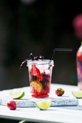 Delicious refreshing lemonade with basil, lime and strawberries. Summer drink with ice. Home made production.