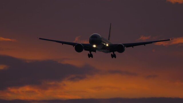 Airplane approaching over ocean at sunset backgfround