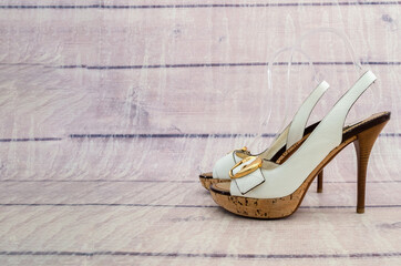 white women's sandals with a large heel on a wooden background. Fashionable summer sandals. Copy of...
