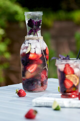 Delicious refreshing lemonade with basil, lime and strawberries. Summer drink with ice. Home made production.