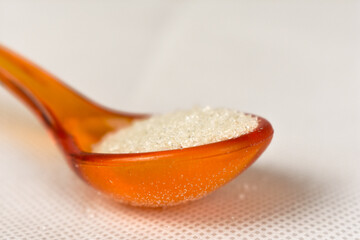 spoon with sugar on a white background