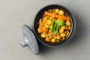 Vegetarian pilaf grey in a pot decorated with greenery top view