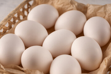 Eggs in a square wicker basket on parchment paper. Close up.
