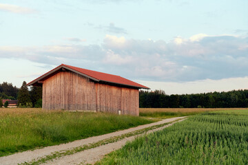 Wanderweg Jakobsweg mit Scheune und Wald im HIntergrund