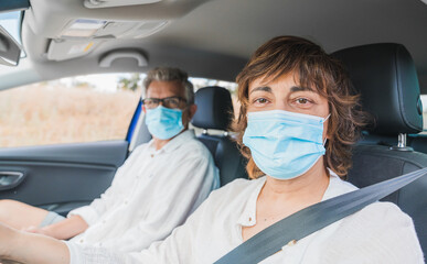 New normal. Female driver with a medical face mask driving a car with a passenger. Health protection. Family in the car protected by a mask safety and pandemic concept. Coronavirus. Social distance.