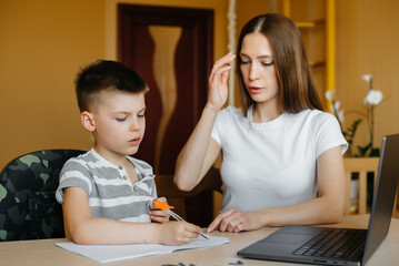 A mother and her child are engaged in distance learning at home in front of the computer. Stay at home, training