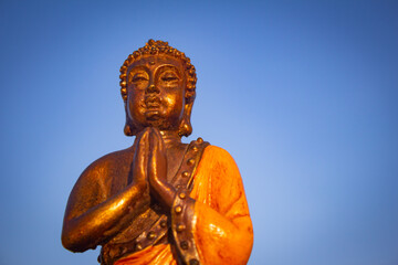 Fototapeta na wymiar Closeup view of Buddha against blue sky background