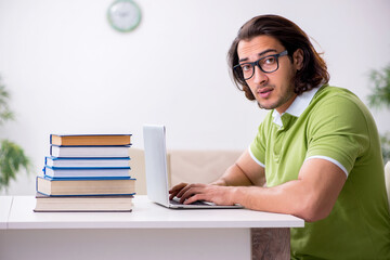 Young male student preparing for exams at home