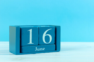 wooden calendar with the date of June 16 on a blue wooden background, World seaTurtle Day