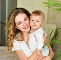 Mother and baby playing and smiling. Happy family.Home interior.