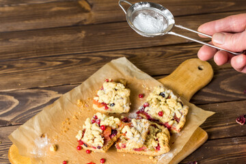  the cook sprinkles icing sugar on the cake.