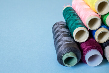 skeins of multi-colored threads lie a hill on a blue background.