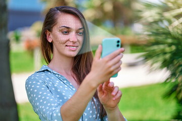 Biometric identification. Modern woman scans face with facial recognition system on phone