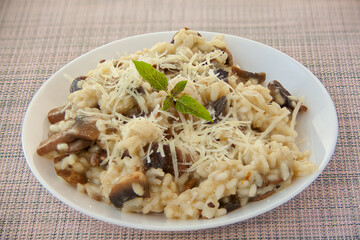 Tasty appetizing risotto on  white plate on  wooden table
