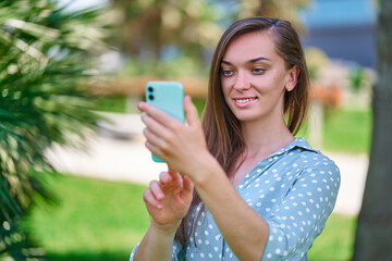 Young woman uses smartphone outdoors. Modern people with digital mobility lifestyle