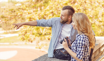 Man and woman having date outdoor. Girl wit a photo camera and her boyfriend.