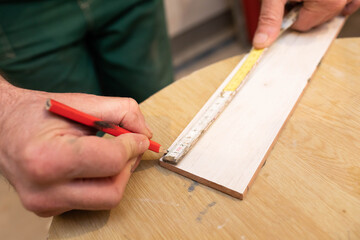 A construction worker measures and prepares to cut ceramic tiles