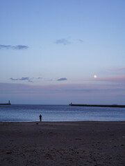 Fototapeta na wymiar Woman looking out to sea in the evening at South Shields