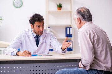 Fototapeta premium Old patient visiting young male doctor
