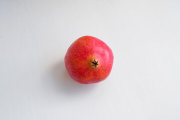 Red pomegranate top view, from afar. On a light background