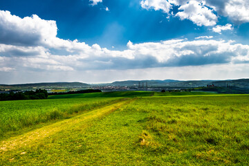 Rural Landscape With Sunlit Clouds In Front Of The Skyline Of Vienna In Austria
