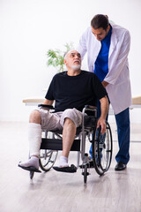 Fototapeta na wymiar Old injured man visiting young male doctor traumatologist