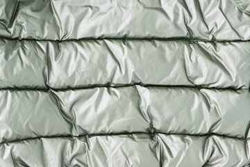 background of light green metalic fabric with stitched lines on it. Copy space for text. Luxury style concept