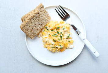 Scrambled eggs on a white plate. Healthy food or breakfast concept.