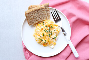 Scrambled eggs on a white plate. Healthy food or breakfast concept.