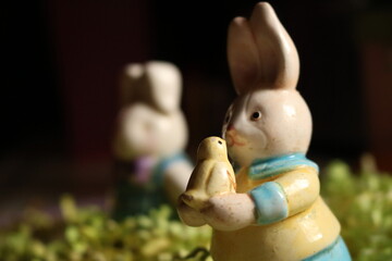 ceramic figure of cute easter bunny grabbing cute yellow duck bird - Powered by Adobe