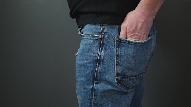 Man take out pocket with money from jeans. Close up