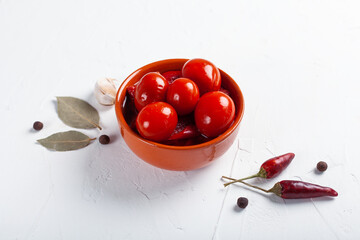 Salted red tomatoes with ingredients on a white table