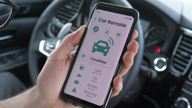 Using smartphone mobile device while sitting inside of the vehicle car to check on the car condition