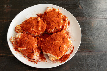 Chicken Thighs Seasoned with Paprika for Hungarian Chicken Paprikash: Raw chicken thighs sprinkled with Hungarian sweet paprika and pimenton (smoked paprika)